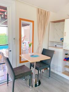 a dining room with a table and two chairs at ปูณิสาวิลล่าPoonisavilla in Ban Khlong Kao (6)