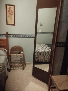 a mirror in a bedroom with a bed and a bed sqor at Hospedería Lucano in Córdoba