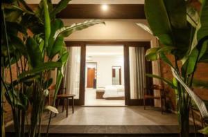 a living room with potted plants in the entry way at Griya Shanti Suites in Sanur