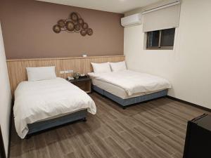 Zimmer mit 2 Betten, einem Tisch und einem Fenster in der Unterkunft Aimei Hotel in Jincheng