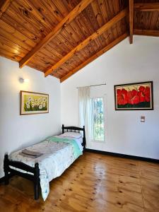 a bedroom with a bed and a wooden ceiling at La joyita in Ituzaingó