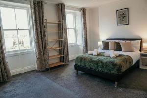 a bedroom with a bed and two windows at The Georgian Townhouse - 4 Bed House in Whitehaven