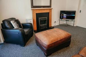 a living room with a chair and a fireplace at The Georgian Townhouse - 4 Bed House in Whitehaven