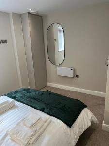 1 dormitorio con 1 cama con espejo grande en TIB Property Investments, Centenary House, 53 North St, en Leeds