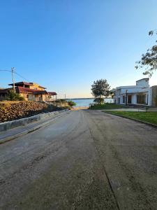 an empty street with houses and the ocean in the background at La joyita in Ituzaingó +17 photos