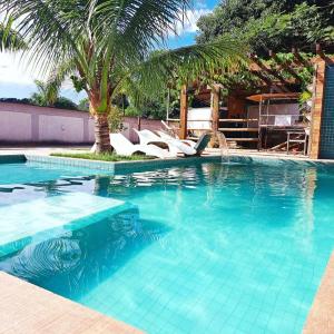 una piscina con sillas y una palmera en Casa com piscina e muita tranquilidade en Río de Janeiro