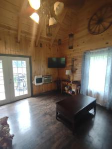 a living room with a table and a ceiling fan at Tranquil Waters Cabin in Frenchburg