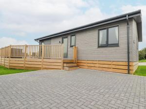 a house with a wooden fence and a patio at Mordros Lodge in Redruth