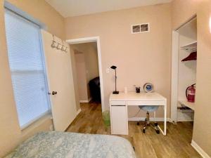 a bedroom with a desk and a bed and a window at Downtown Hobart Cozy 1 Bedroom in Hobart