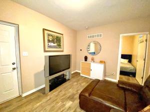 a living room with a couch and a flat screen tv at Downtown Hobart Cozy 1 Bedroom in Hobart