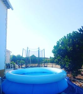 a large blue trampoline in front of a playground at Casa dos pássaros in Carril