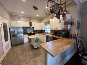 a kitchen with white cabinets and stainless steel appliances at Blueberry Bungalow - Locally Run! Enjoy our PS5! in Taylor