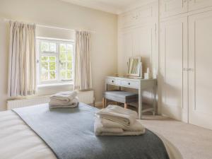 a bedroom with two towels on a bed with a desk at Lower Barrowfield Farm in Beaminster