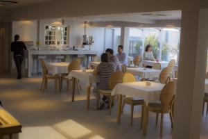 a group of people sitting at tables in a restaurant at Hotel Las Terrazas Business in Chillán