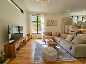 ナッシュビルにあるExtra Spacious 4 Bed / 4.5 Bath Music Row Homeのソファと薄型テレビのあるリビングルーム