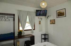 a bedroom with a bed and a window at Pousada Don Raton in Campos do Jordão