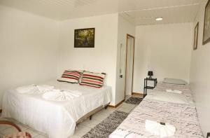 a bedroom with two beds in a room at Pousada Don Raton in Campos do Jordão