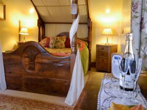 um quarto com uma cama e uma mesa com copos de vinho em Harvest Cottage em Wrexham