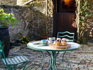 uma mesa com um prato de comida num pátio em Harvest Cottage em Wrexham