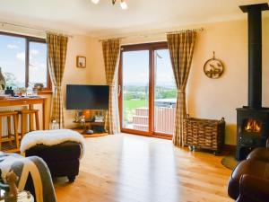 a living room with a fireplace and a stove at Trelaw in Ochiltree