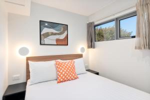 een slaapkamer met een bed en 2 ramen bij Best Western Newmarket Inn & Suites in Auckland