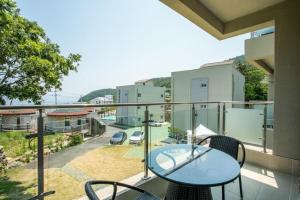 - un balcon avec une table et des chaises dans l'établissement Village Pier Pension - Garden, à Yeosu
