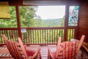 a screened in porch with chairs and a window at Dolly Bear Mountain View in Sevierville