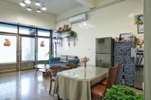 ein Wohnzimmer mit einem Tisch und einem Kühlschrank in der Unterkunft Wanghong Homestay in Altstadt von Hengchun