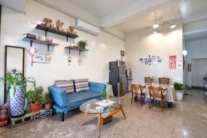 a living room with a blue couch and a table at Wanghong Homestay in Hengchun