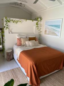 - une chambre avec un lit et une couverture orange dans l'établissement 600m to Beach, Family Entertainer, Aircon, Pool & Pizza oven, à Maroochydore