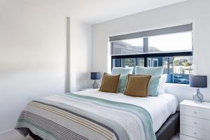 een slaapkamer met een groot bed en een raam bij Okiwi Landing in Raglan