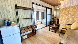 a living room with a refrigerator and a bedroom at glampark S.O.P Fuji Kawaguchi Lake in Fujikawaguchiko