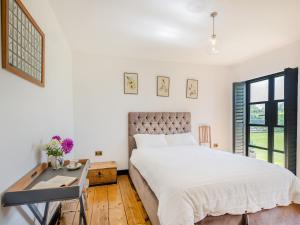 een witte slaapkamer met een bed en een bureau bij Little Orchard in Wood Dalling