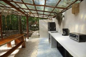 a kitchen with a counter with a sink and a bench at Magical jungle Eco Cabana -Tulum in Macario Gomez