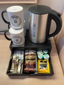a drawer with a coffee mug and other food items at Jubilee Hotel Victoria in London