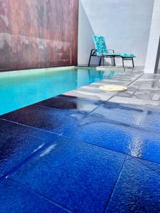 a blue swimming pool with a chair in a room at Q Resorts Paddington in Townsville