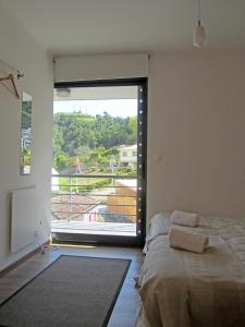 een slaapkamer met een bed en een groot raam bij Casa Das Furnas in Furnas