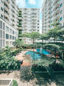 un complexe d'appartements avec une piscine en face des bâtiments dans l'établissement Swiss-Belcourt Bogor, à Bogor