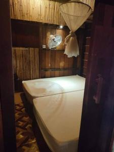 um quarto com uma cama branca e uma ventoinha em ST 63 Home Stay & Tour Kampong Khleang em Kâmpóng Khleăng