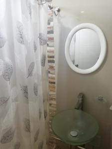 W łazience znajduje się zielona umywalka i lustro. w obiekcie Apart Hotel Costa Verde w mieście Tacna