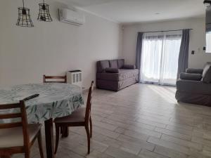 ein Wohnzimmer mit einem Tisch, Stühlen und einem Sofa in der Unterkunft Ak´Para in Tandil
