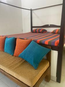 two beds with colorful pillows sitting on a bench at Savenndra Resorts in Malwana