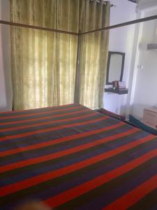a bedroom with a bed with a curtain and a rug at Savenndra Resorts in Malwana