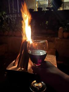 una persona che tiene un bicchiere di vino davanti al fuoco di Glamping Salento con jacuzzi climatizado a Salento