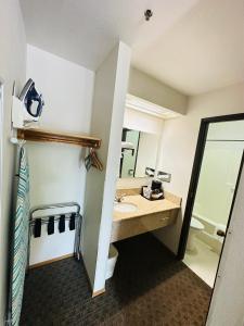 Timberland Inn & Suites في كاسل روك: حمام مع حوض ومرحاض ومرآة