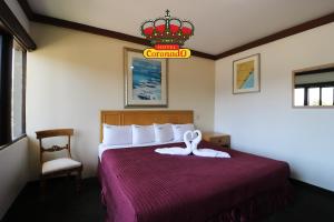 Habitación de hotel con cama con colcha roja en Hotel Coronado, en Ensenada