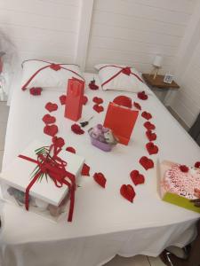 een bed met rode rozen en cadeaus erop bij Keshy island colibri in Baillif