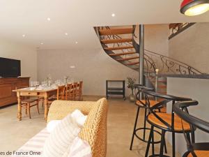 ein Wohnzimmer mit einem Esstisch und einer Wendeltreppe in der Unterkunft Maison spacieuse avec bain nordique et mini ferme en Normandie - FR-1-497-187 in Saint-Patrice-du-Désert