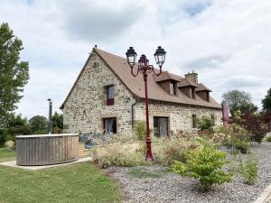 ein Steinhaus mit einer Straßenlaterne davor in der Unterkunft Maison spacieuse avec bain nordique et mini ferme en Normandie - FR-1-497-187 in Saint-Patrice-du-Désert