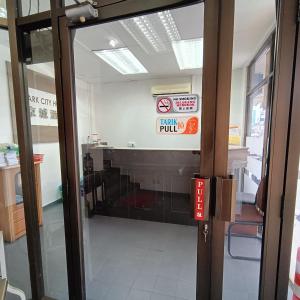 an open door to a building with a sign on it at Park City Motel in Malacca